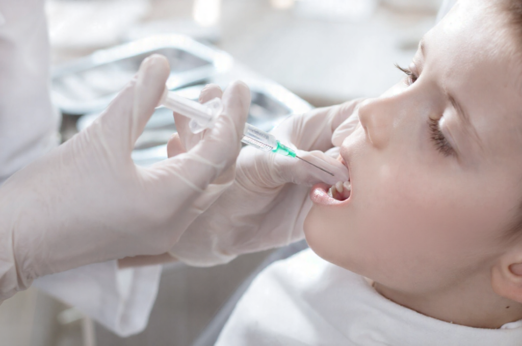 A child receives a comforting, numbing administration of local anesthesia.