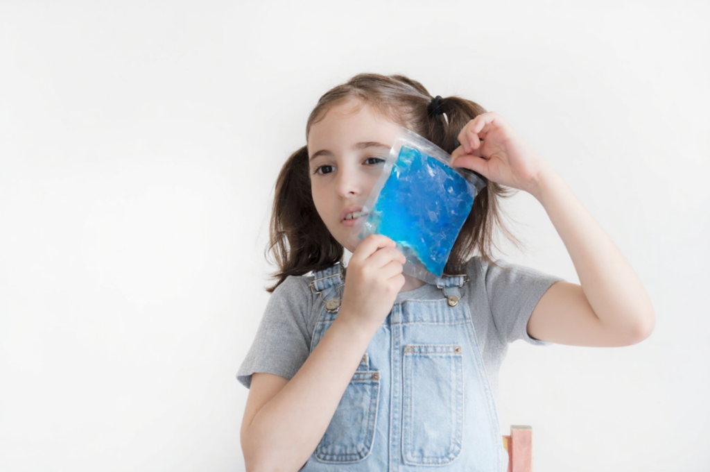 A tranquil child is applying a cold compress at home.