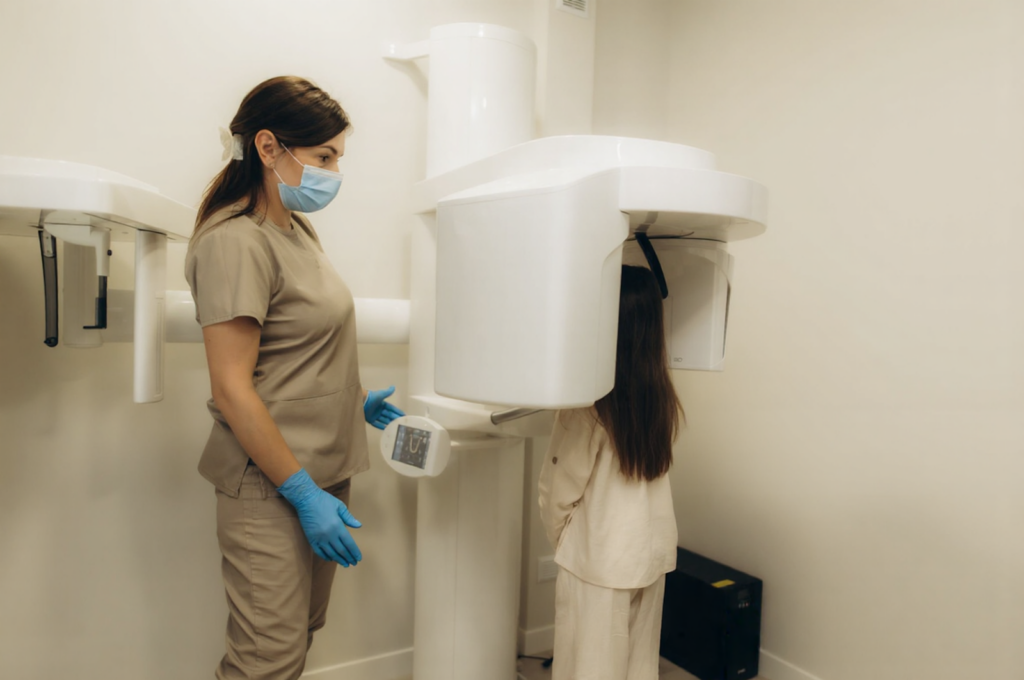 A little girl is having a dental X-ray taken to check the position of her developing permanent teeth.