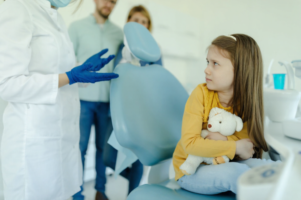 An anxious little girl needs a step-by-step explanation of the tooth extraction process before it happens.