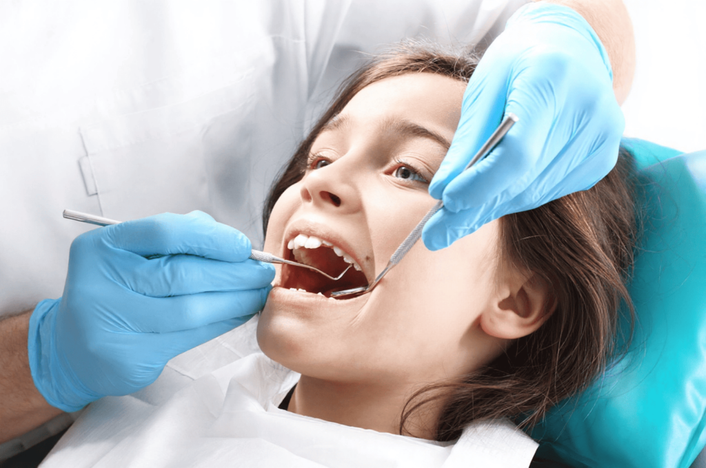A dentist is examining a child's first molar before recommending sealants.