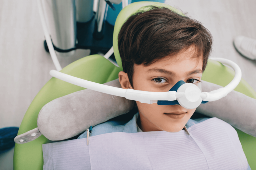 A young boy is undergoing sedation as a calming support measure for his dental extraction.