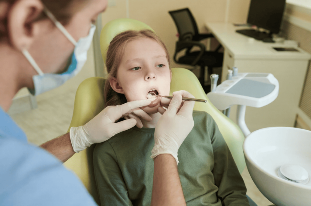 A dentist is examining a girl's teeth to determine whether to use SDF for her.