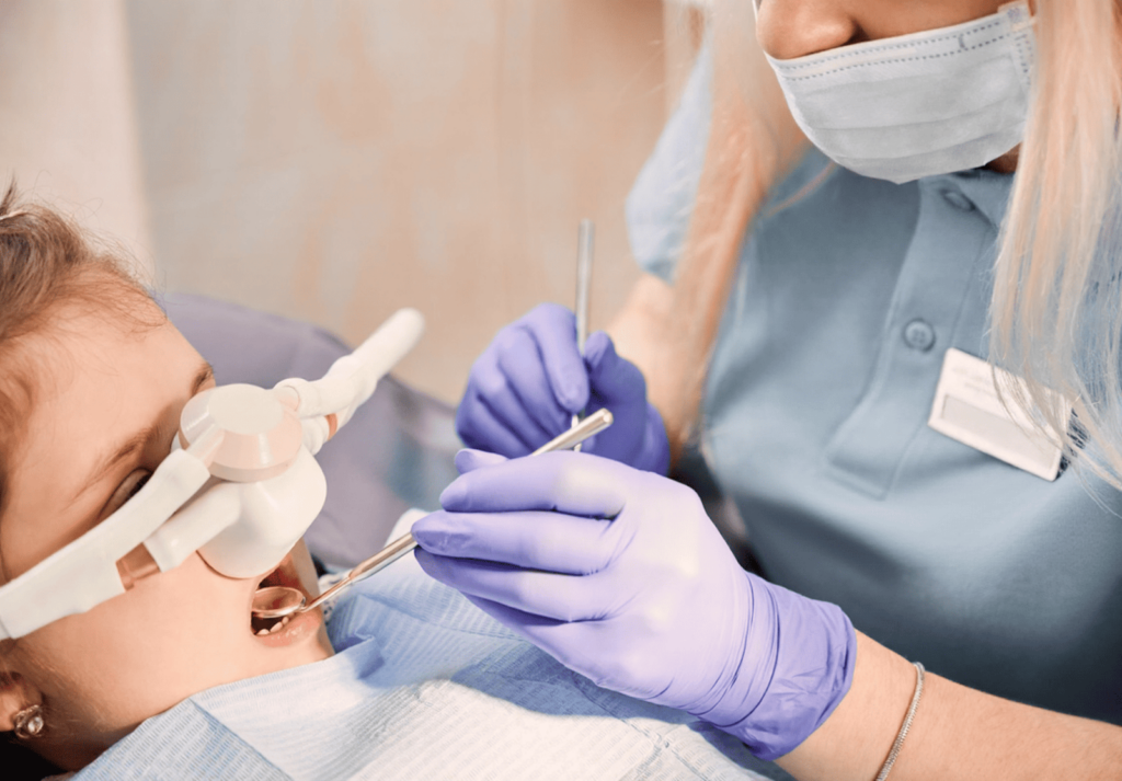 A child is receiving cavity treatment under sedation.