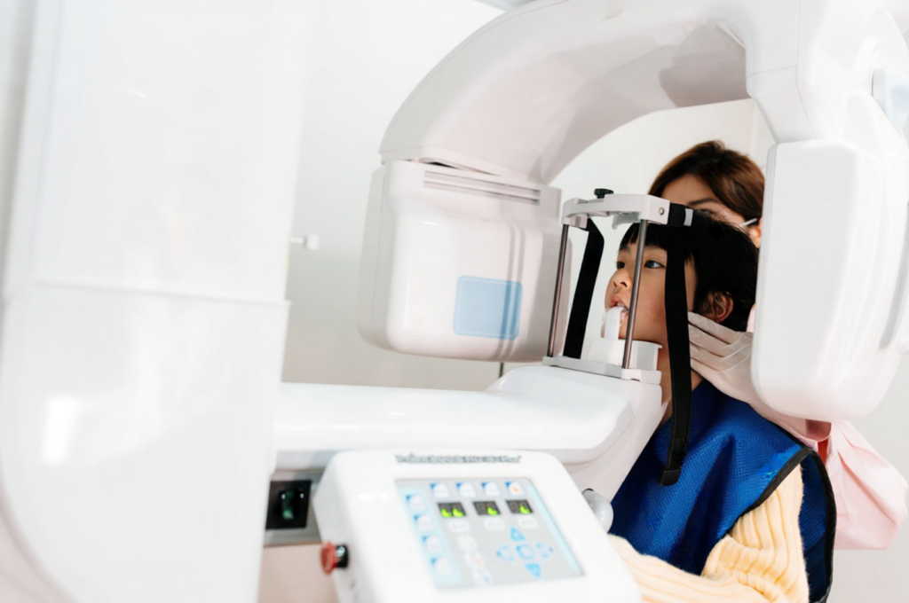 A young girl is getting a routine X-ray to check for cavities.