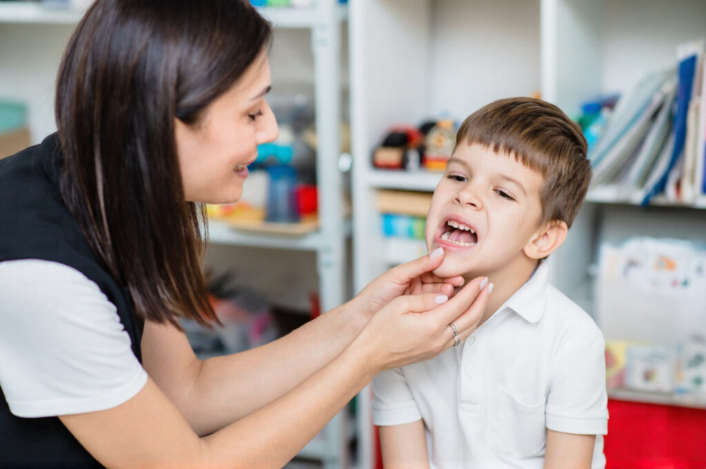 A mother is checking white spots on her child’s teeth.