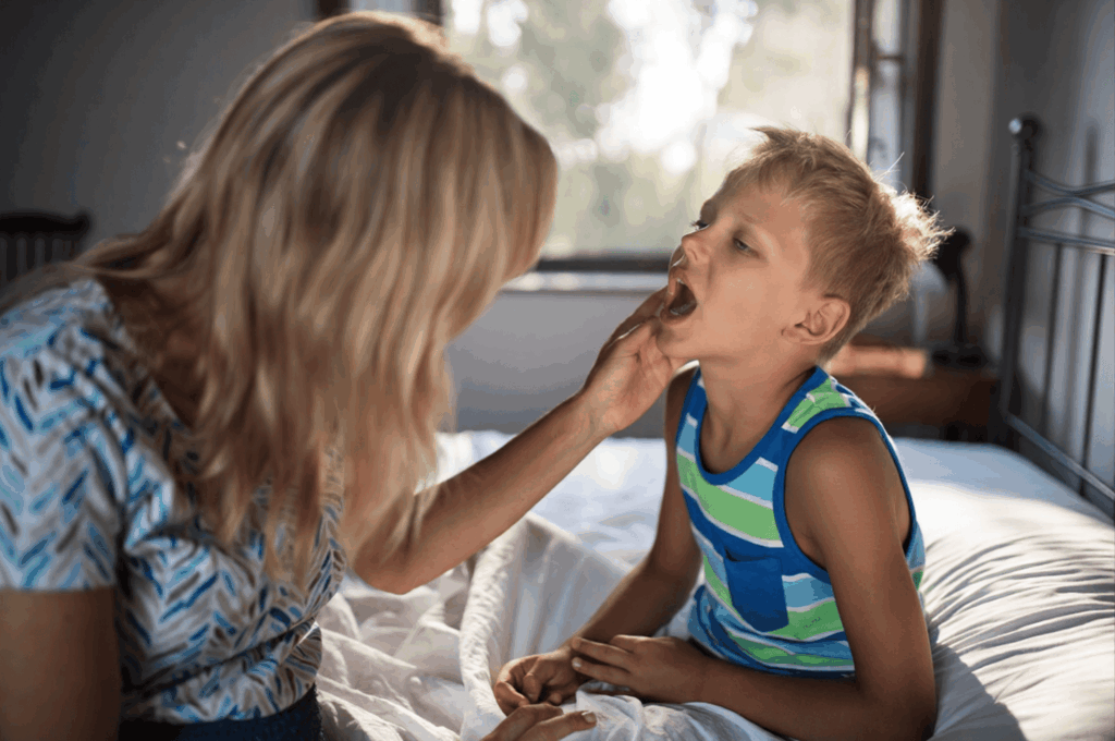 A mother is checking her child's baby tooth.